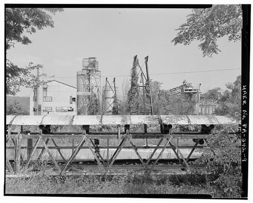 View east from western edge of complex. Collapsed overhead conveyor in foreground carried ganister down to the brickyard from crushing and grinding