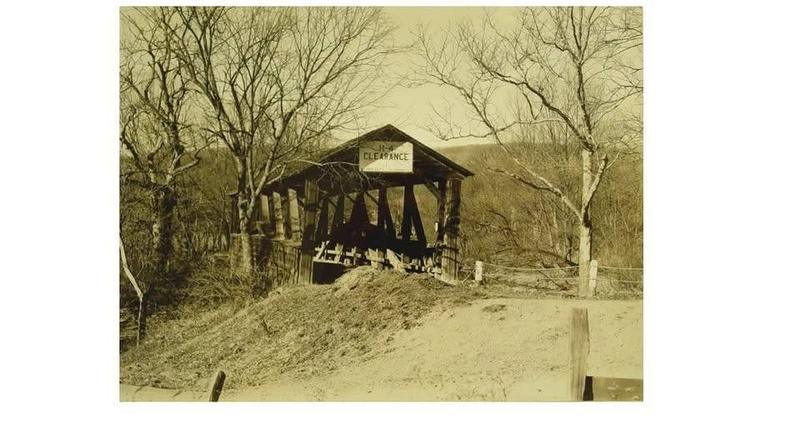 A wooden covered bridge on a dirt road, which Myer Souders identifies as the old Cornpropst Mills bridge over Standing Stone Creek.