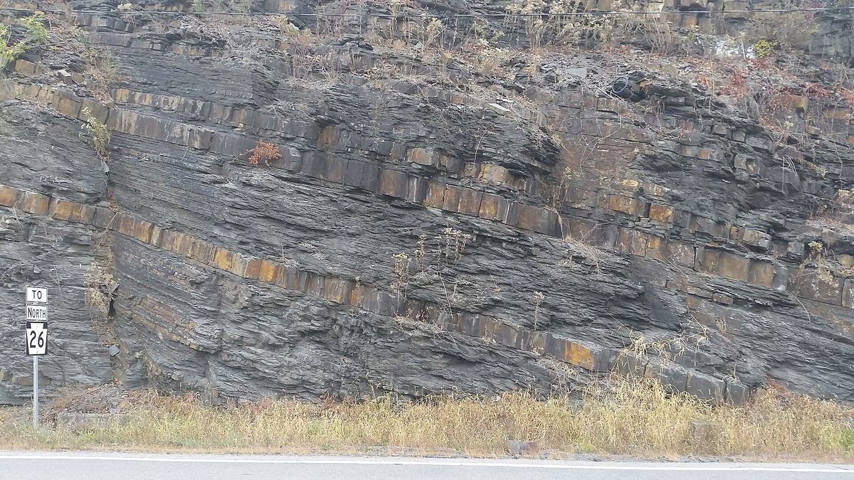 Exposure of the Devonian Brallier Formation in Huntingdon, Pennsylvania, along the ramp from U.S. Route 22 west to Pennsylvania Route 26 north. Facing roughly northeast. Thick blocky beds are sandstone and the intervenin